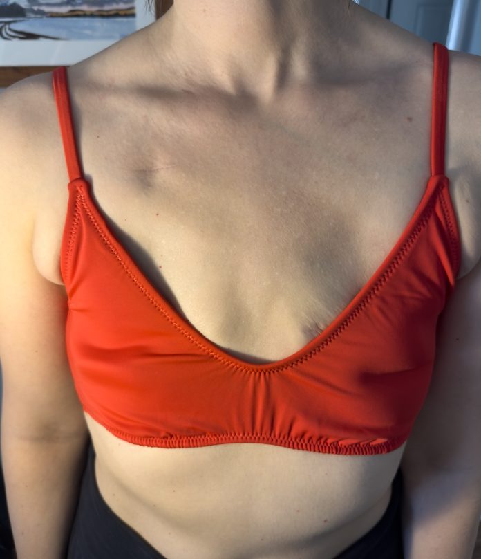 Fit reference image showing swim top gaping on flat chest. Research artifact.