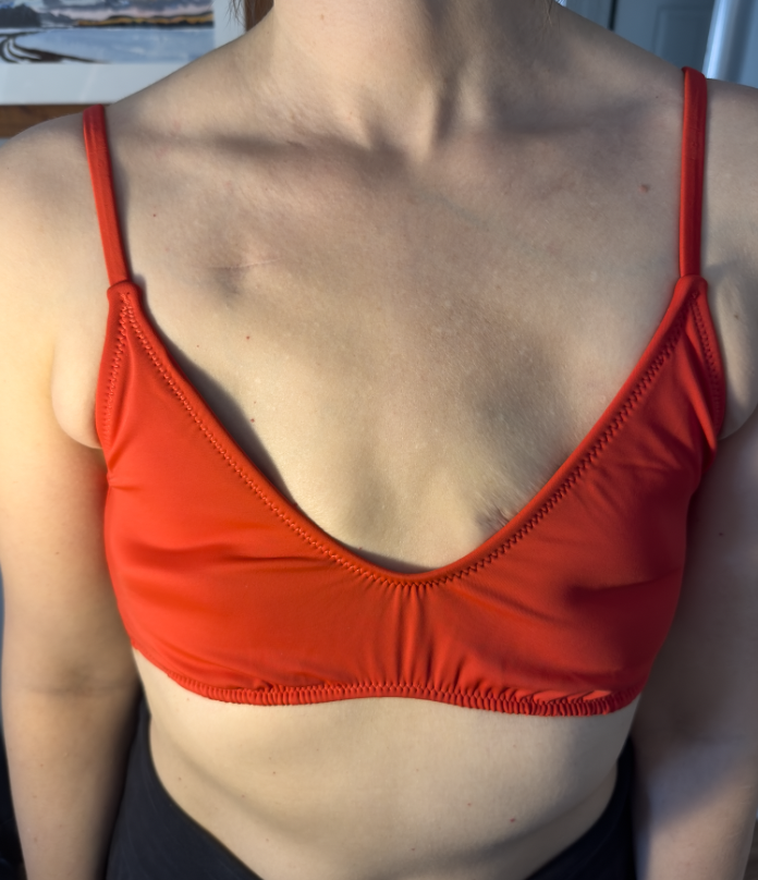 Fit reference image showing swim top gaping on flat chest. Research artifact.